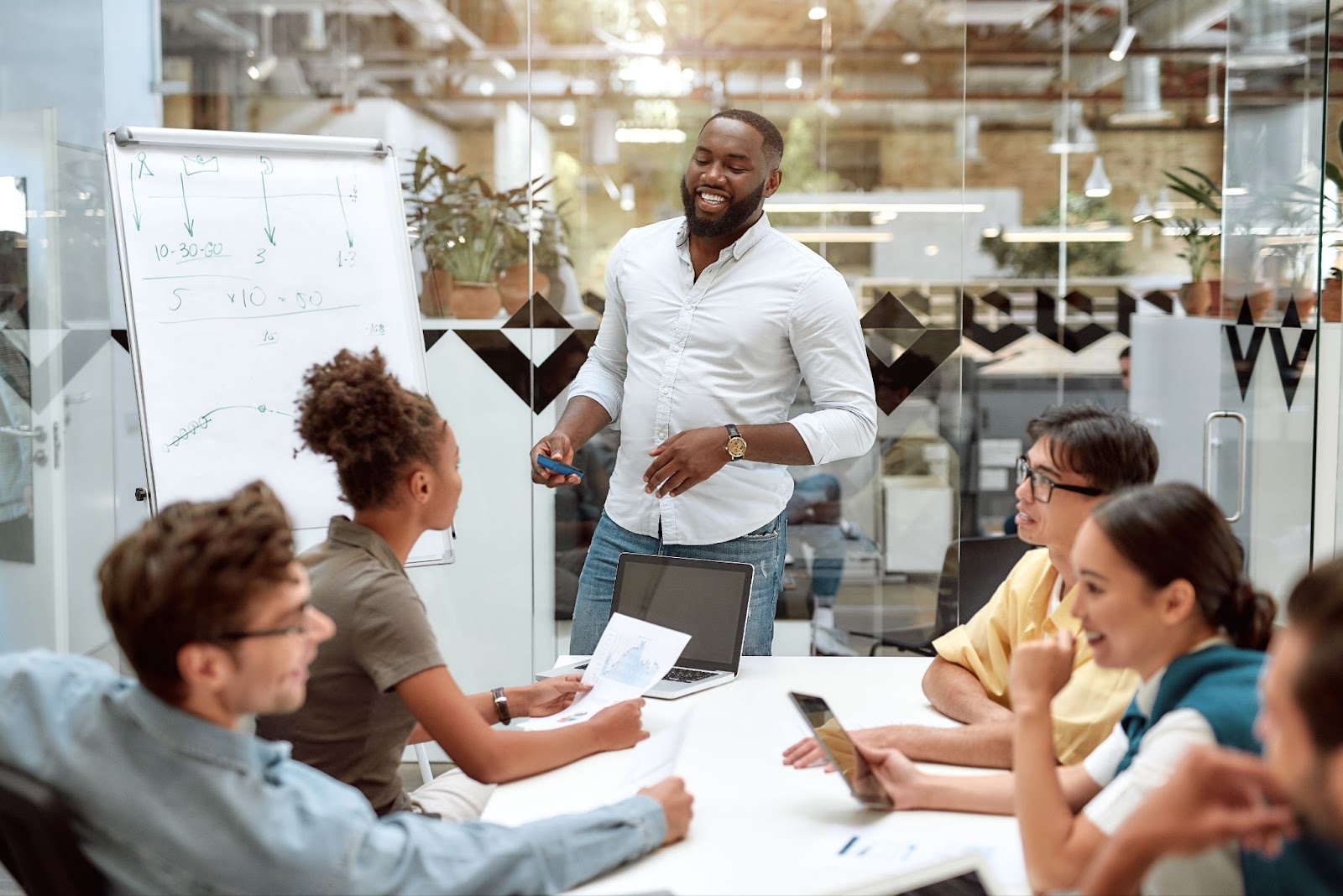 A man presents to colleagues in a commercial construction firm, discussing project plans and strategies for success.