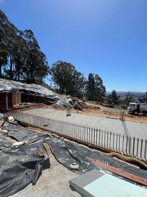 A panoramic view of a construction site atop a hill, showcasing commercial real estate development in progress.