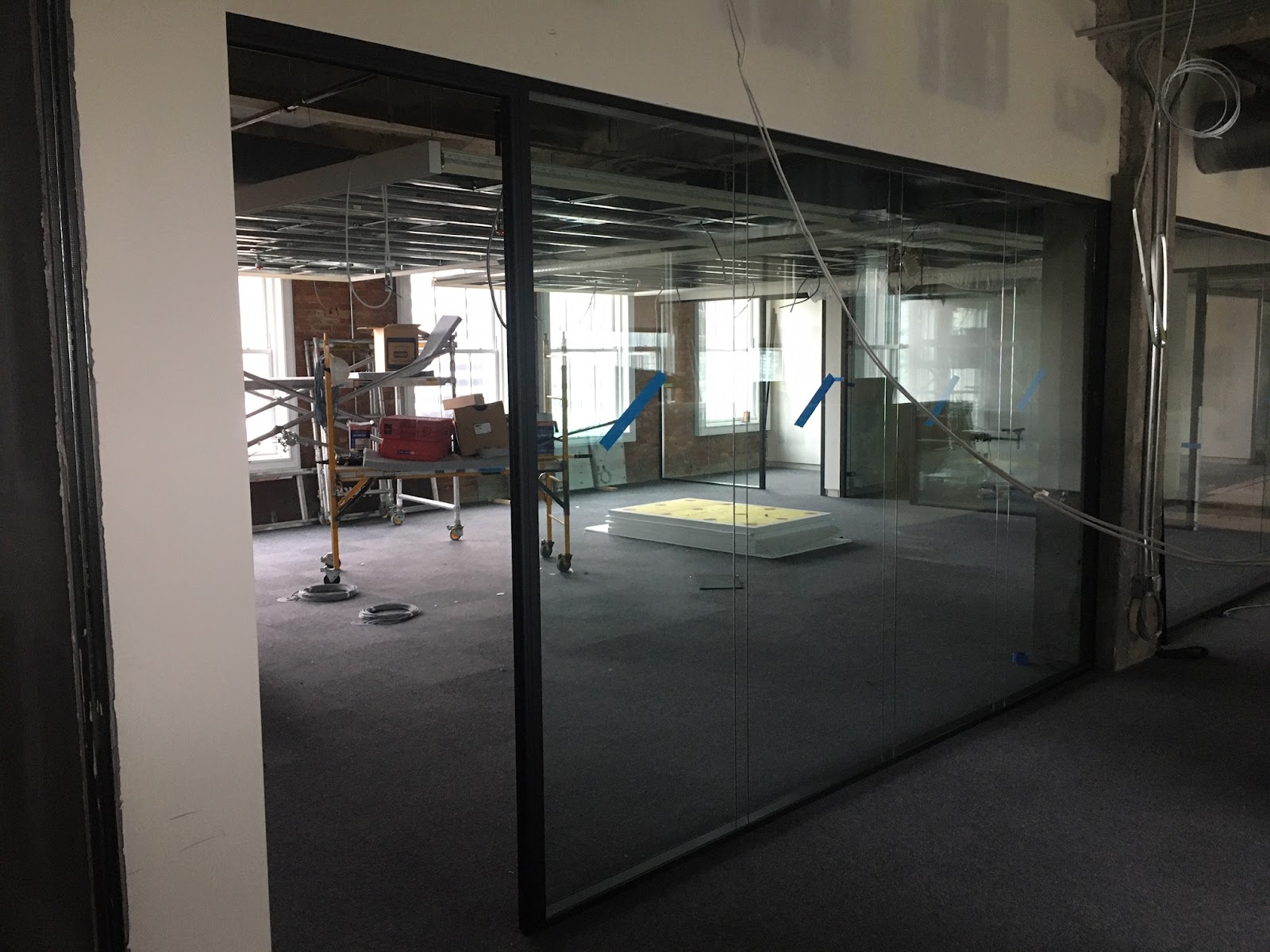 An open large glass door in a modern office, symbolizing accessibility in commercial real estate development.