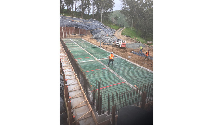 Construction workers pouring concrete on a commercial site, showcasing teamwork in real estate development.