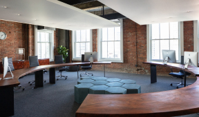 A circular desk and chairs in an office.