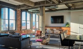 Interior of an office with a spacious window and a comfortable couch.