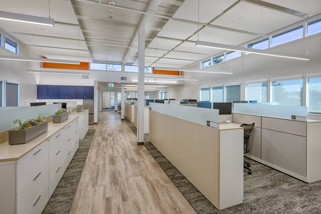 An expansive office featuring wooden floors and a large open layout, promoting a collaborative work environment.