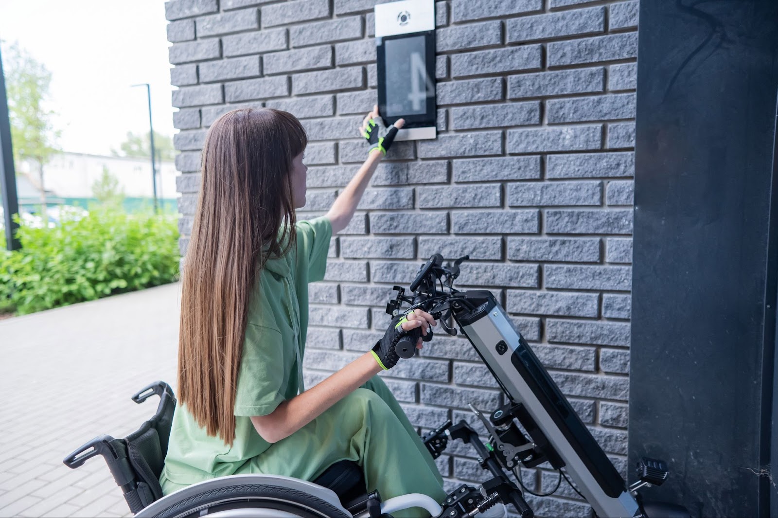 A woman in a wheelchair uses a tablet, highlighting accessibility in commercial building upgrades for ADA compliance.