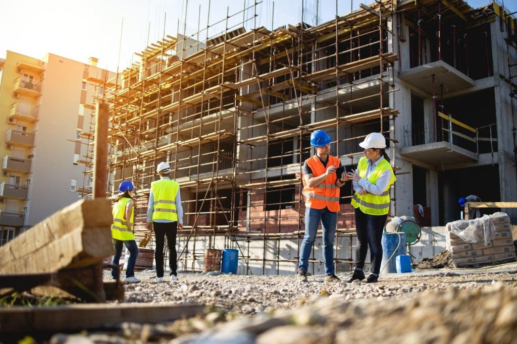 Construction workers collaborating on a building site, wearing safety gear and engaged in various tasks