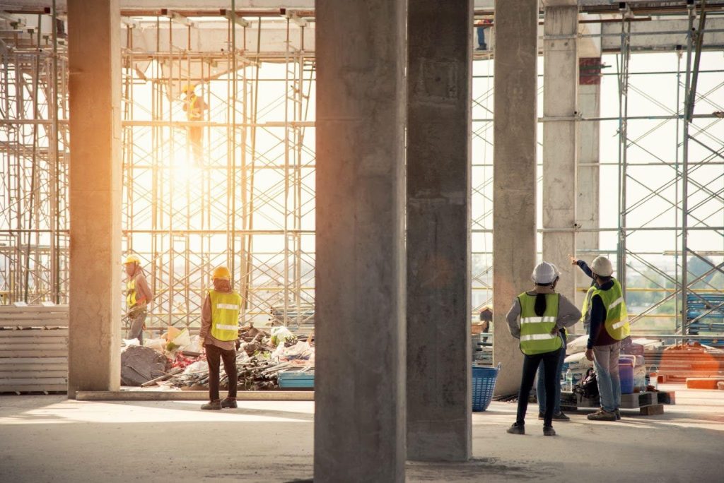 Construction workers diligently engaged in building a large structure, showcasing teamwork and industry in progress