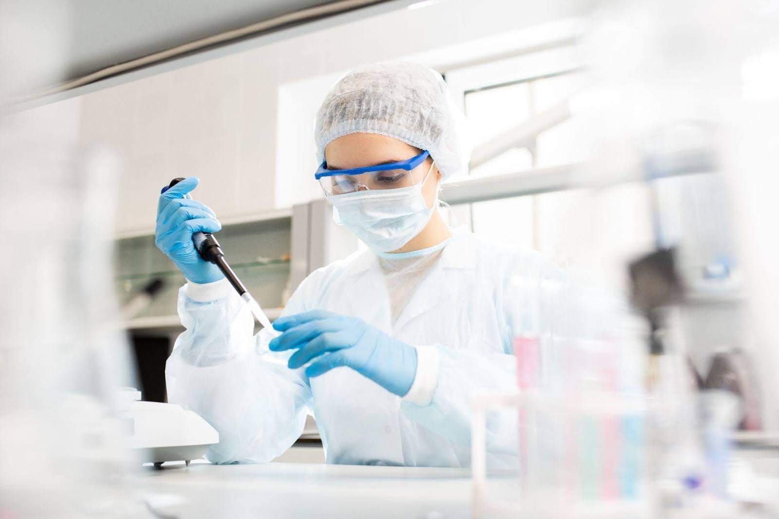 A woman in a lab coat and gloves demonstrates professionalism in a lab