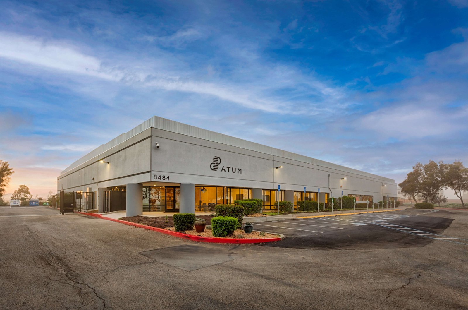 A large industrial building facade with a spacious parking lot showcasing its scale