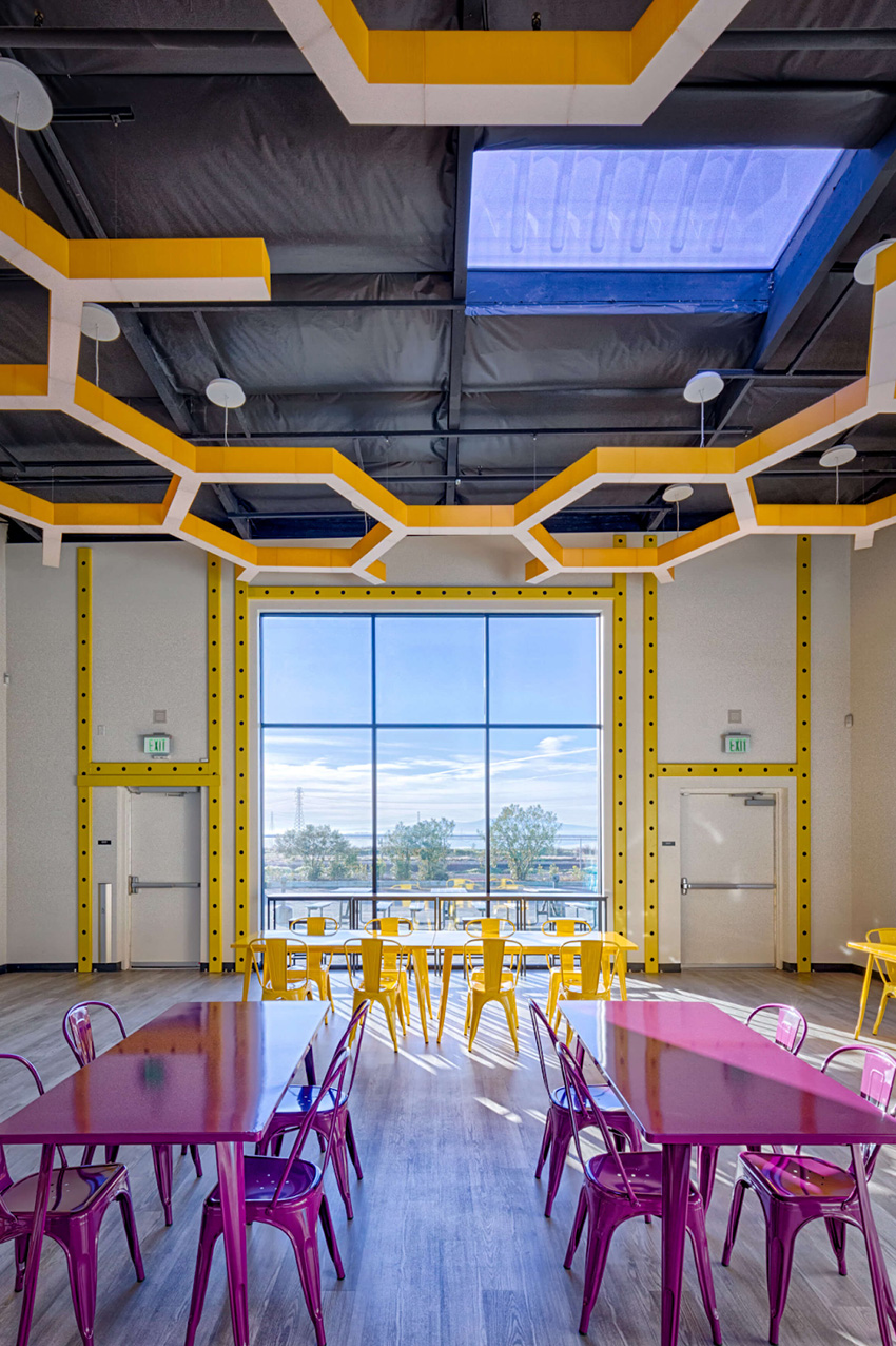 A vibrant room featuring colorful tables and chairs arranged for social gatherings or meetings