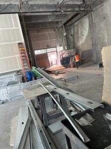 Interior of a large building under construction with scattered construction equipment